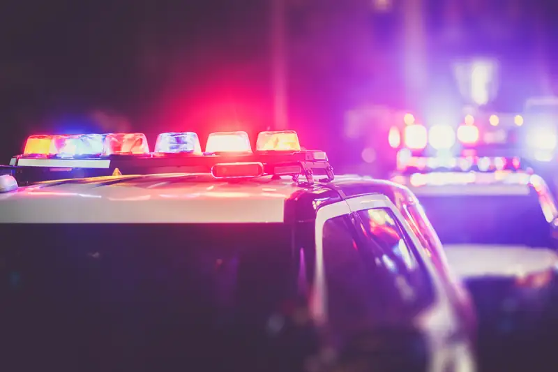 Patrol cars with their emergency lights on at night